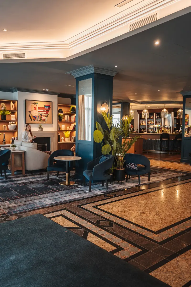 A hotel lounge with armchairs and warm light